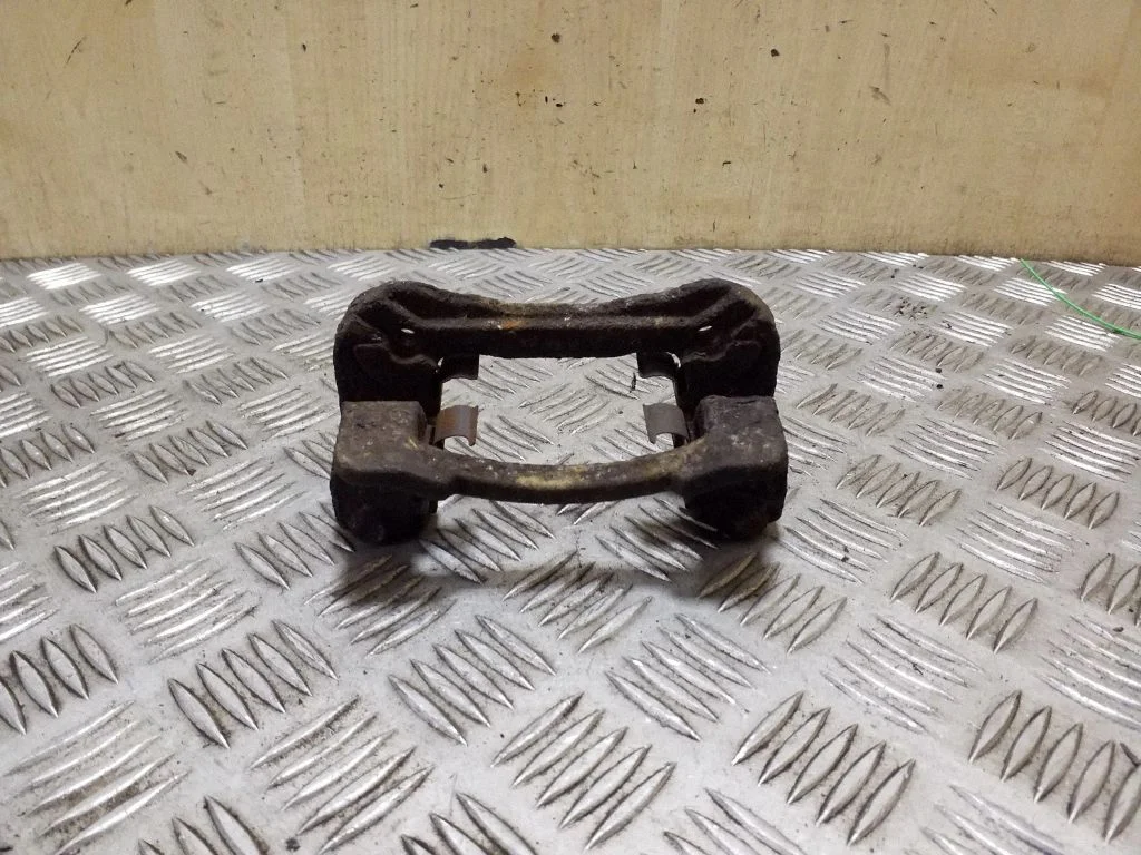 Piduriklotside hoidik/kandur (tagumine) – vasak