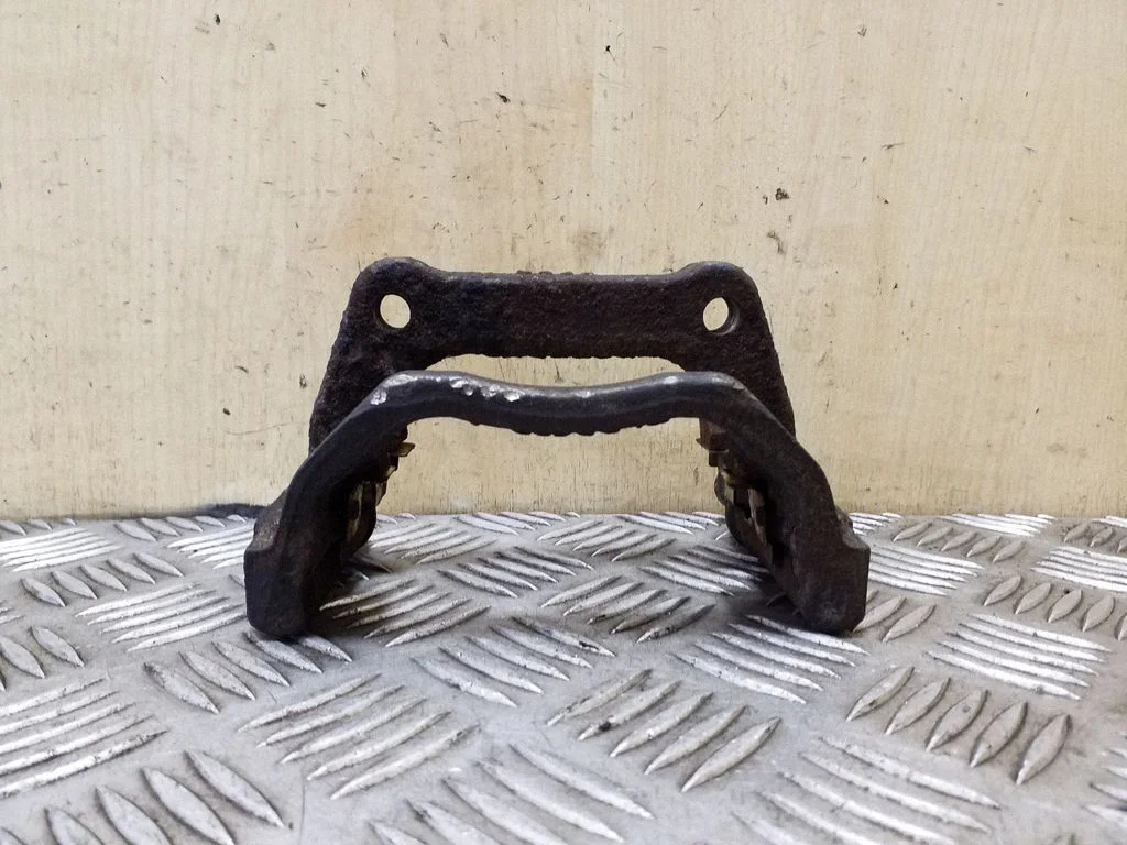 Piduriklotside hoidik/kandur (tagumine) – vasak