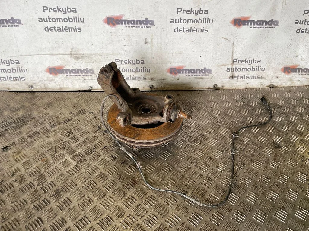 Priekšējais rumbas turētājs (šarnīra dakša) – priekšējā kreisā