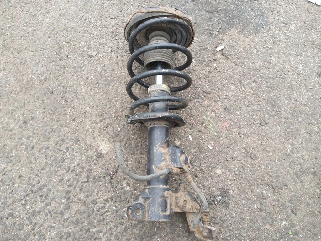 Front shock absorber with coil spring – left