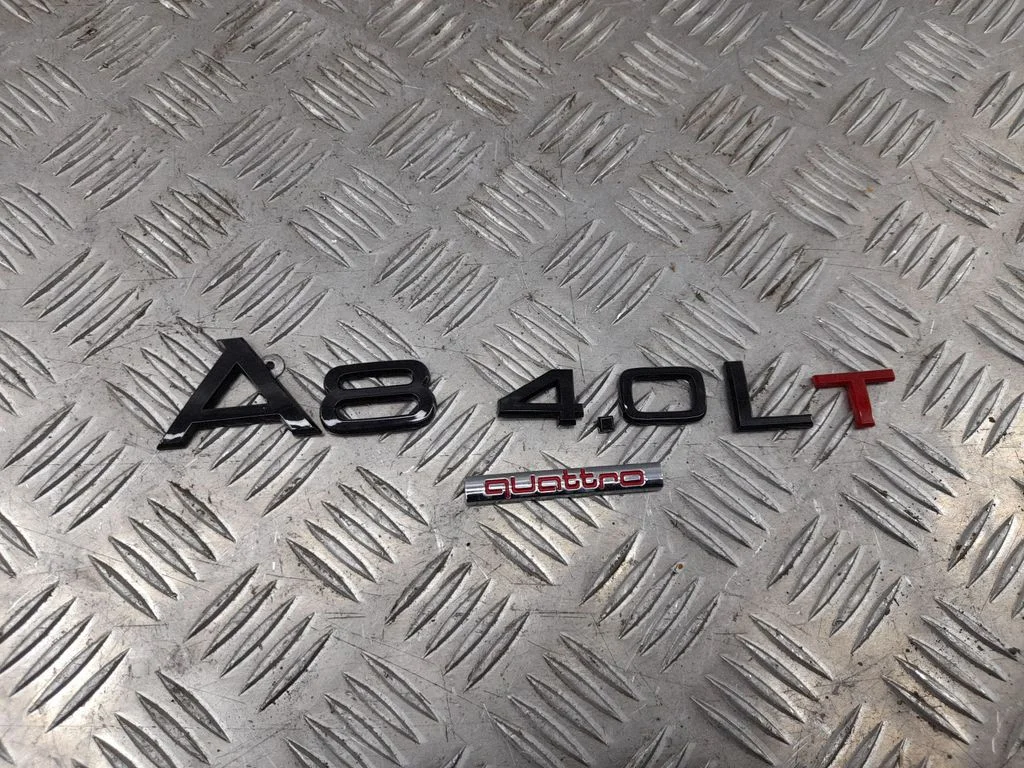 Ražotāja emblēma/modeļa burti – aizmugurējā